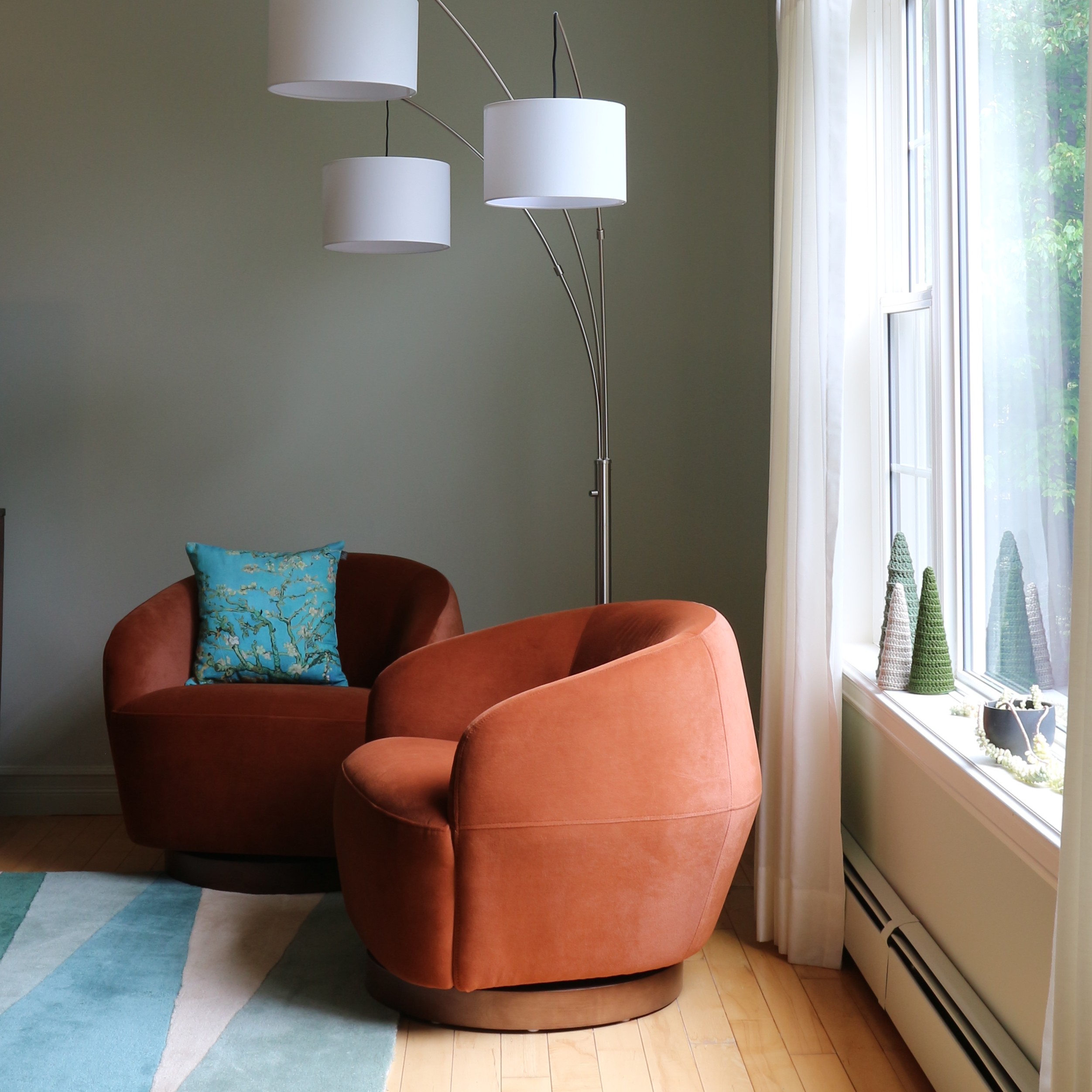 modern round swivel lounge chairs sage walls turquois pillow and rug floor lamp