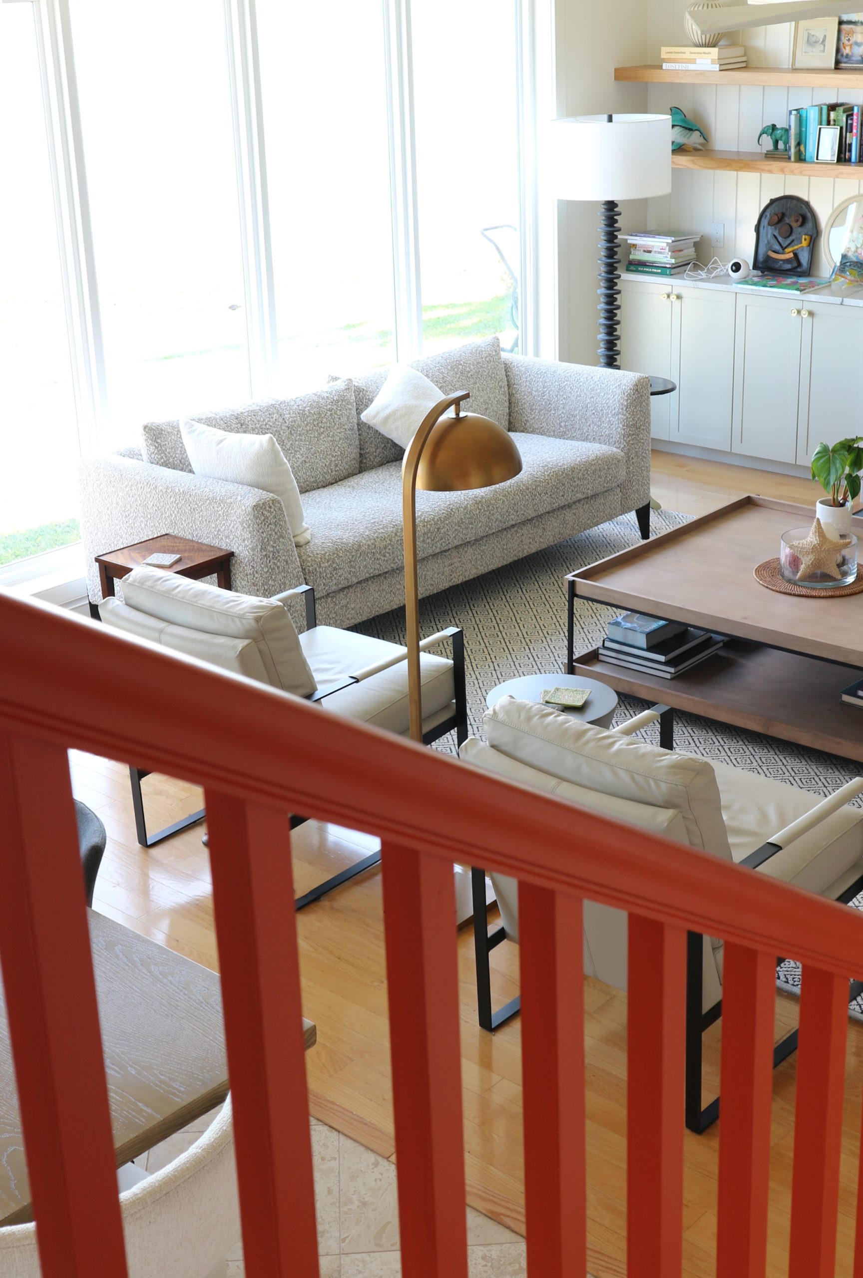 view of living room from orange staircase handrail