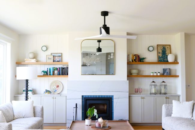 Fireplace wall. Blue veined stone fireplace with built-ins in a warm modern coastal Nova Scotia oceanfront home