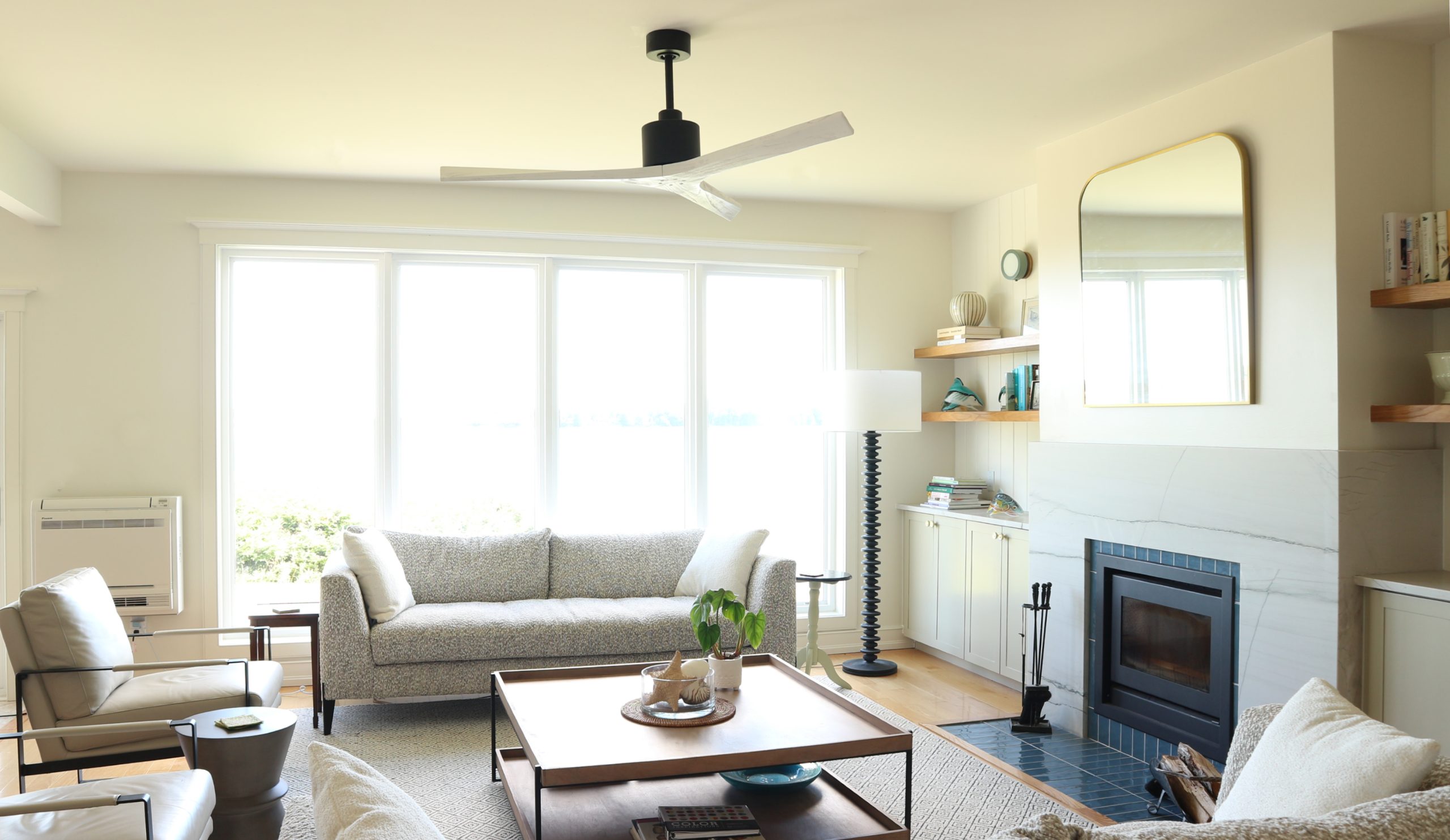 Modern coastal living room with blue tile fireplace and ocean views in a Nova Scotia home