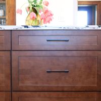 brown kitchen cabinet with white and black counter